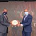 Latmar Mukasa the chairman Uganda Insurers Association handing over an award to one of the winners.